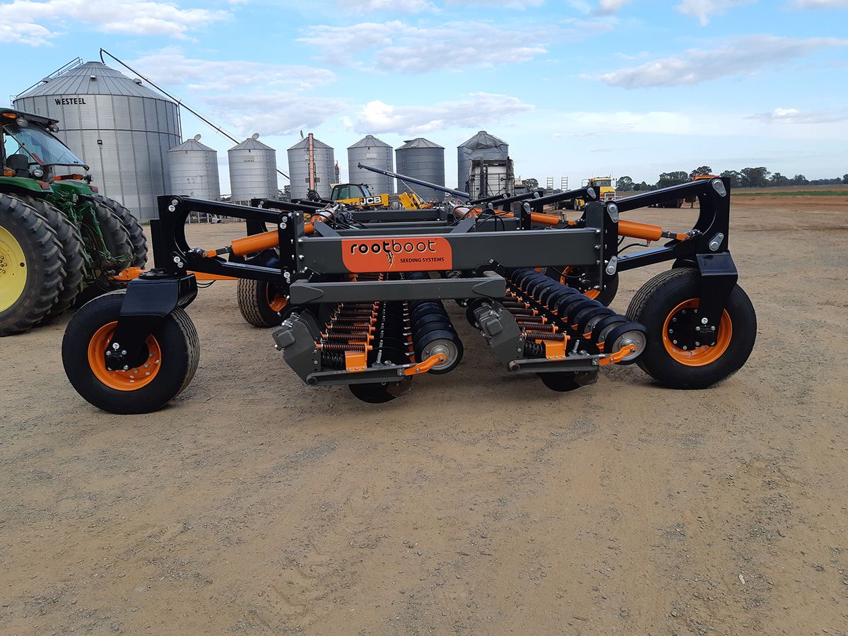 Rootboot seeding boots mounted on a seeder bar at sunrise